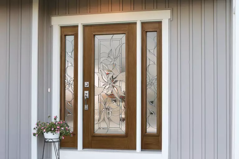 Brown front door with low-E glass windows on a gray house.