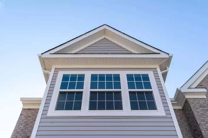 Vinyl windows on the side of a home with blue sky in the background