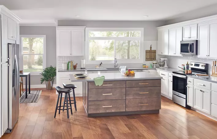 A bright, white kitchen with wooden accents that has a lot of natural light due to new window installations.