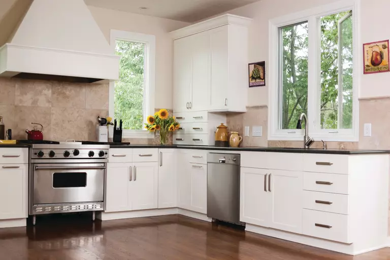 A kitchen with several tall casement windows.