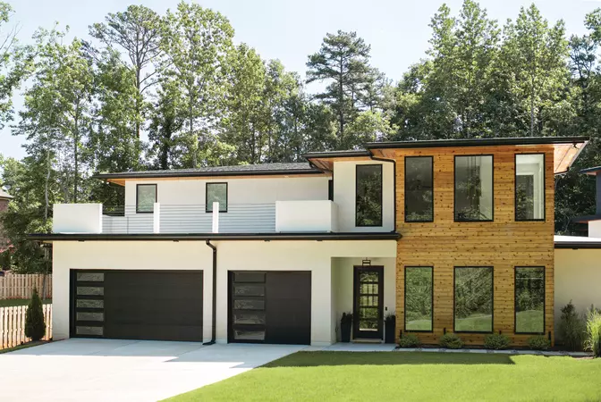 Black flush panel garage door with clear windows on a modern home
