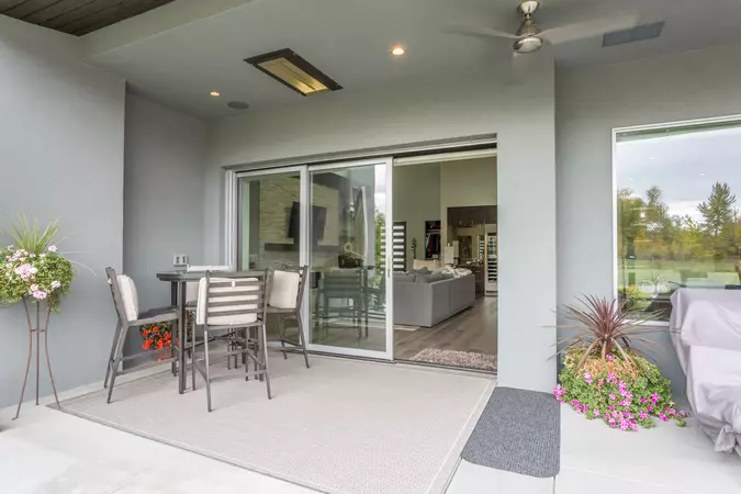 A covered porch with a multi-slide patio door connecting to a living room 