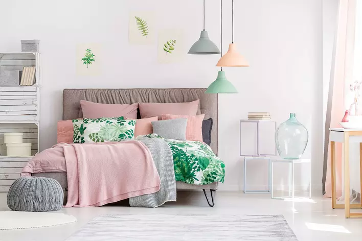 An open and airy bedroom decorated with botanical elements and Peach Fuzz-colored<br>accents