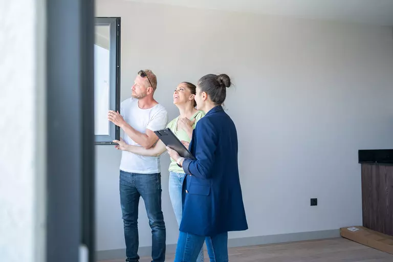 A woman showing a man and woman different kinds of windows.