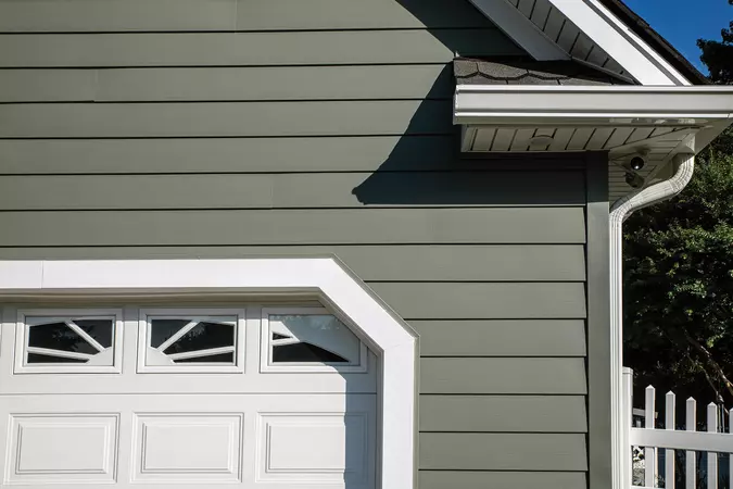 Close-up of ASCEND Composite Cladding in Mountain Fern, 4" corner post, AMI 4000 Series Charter Oak Soffit and Performance G8 trim coil on a traditional home