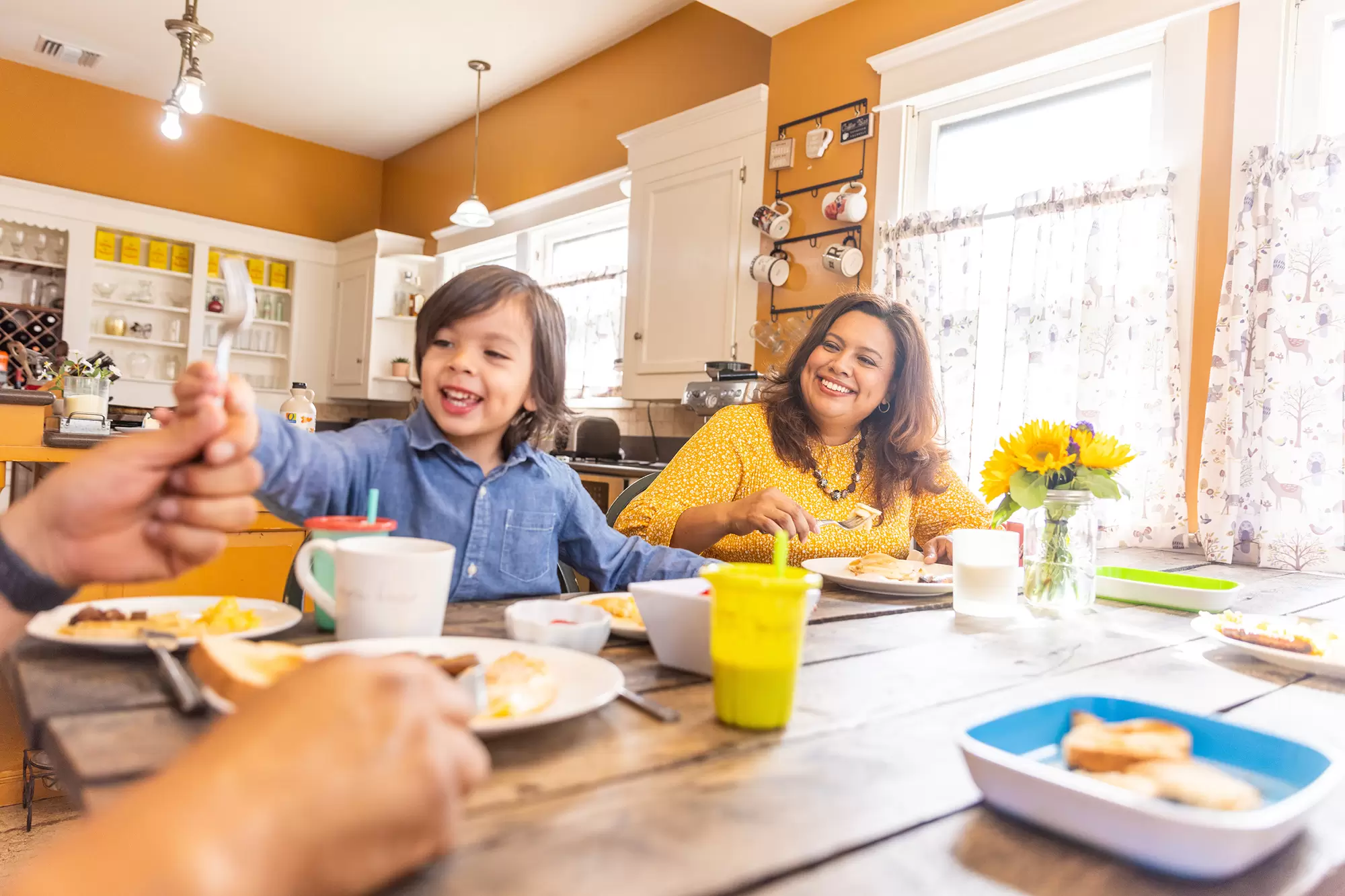 Family eating breakfast at a dining room table.