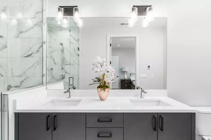 A modern white bathroom with marble tile and white countertops