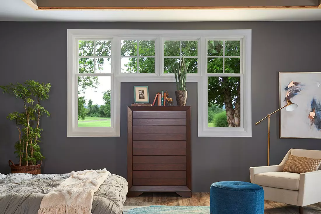 Three double-hung windows in a bedroom for adjustable ventilation.