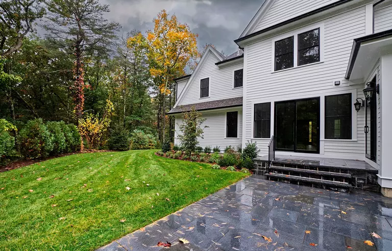 Front yard of a home with rainclouds above.