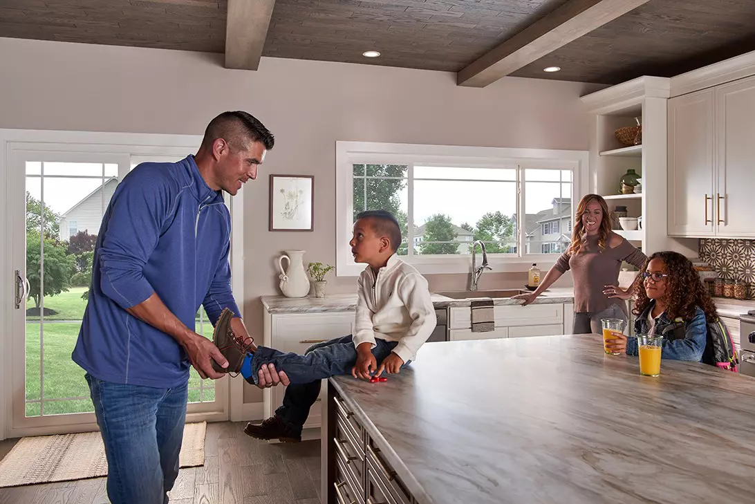 Family inside a kitchen with a sliding patio door and sliding window.