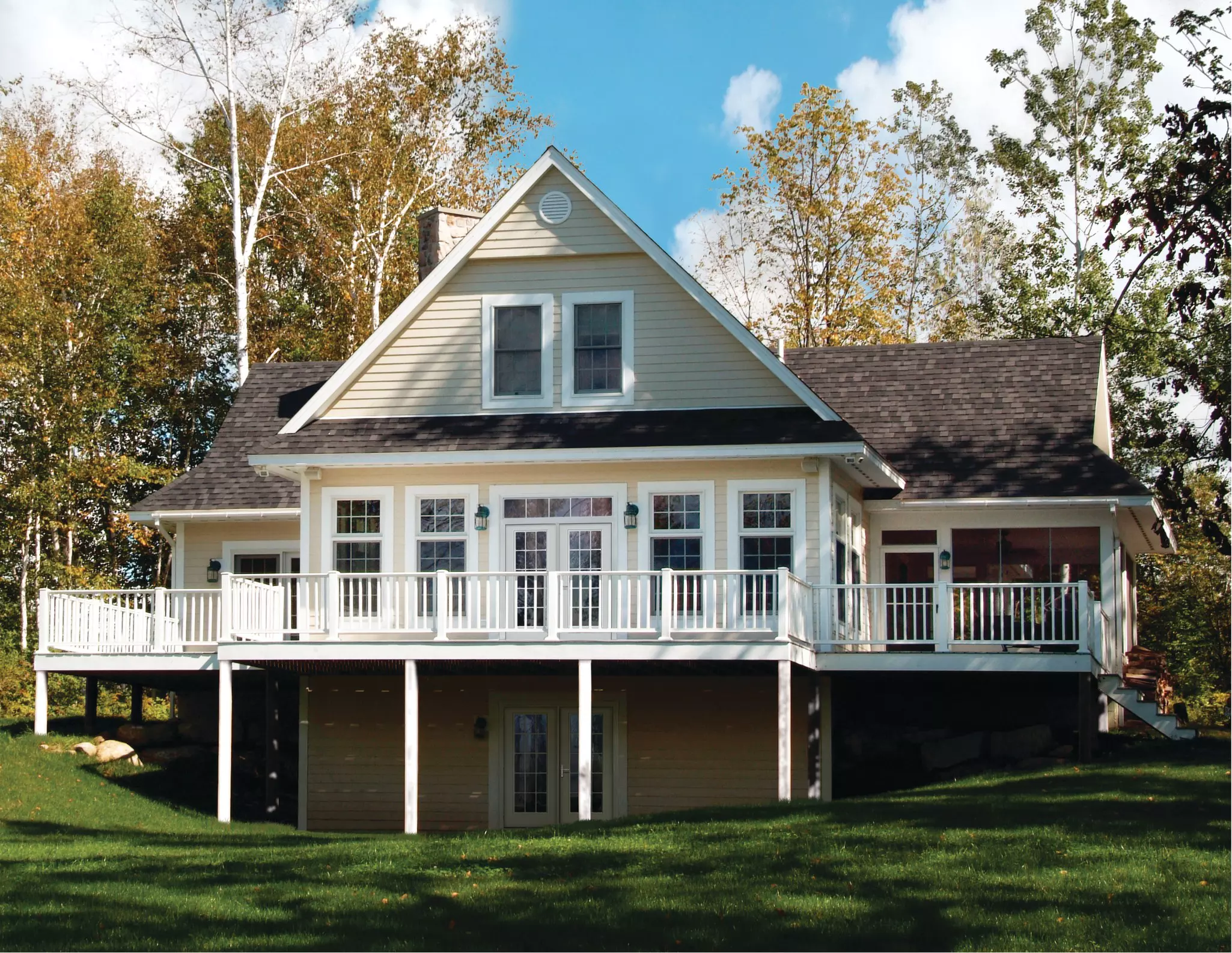Multiple-story home with white windows and entry doors. 