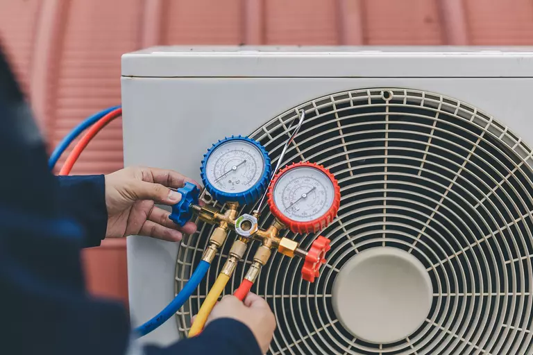 An HVAC professional checking values on valves.