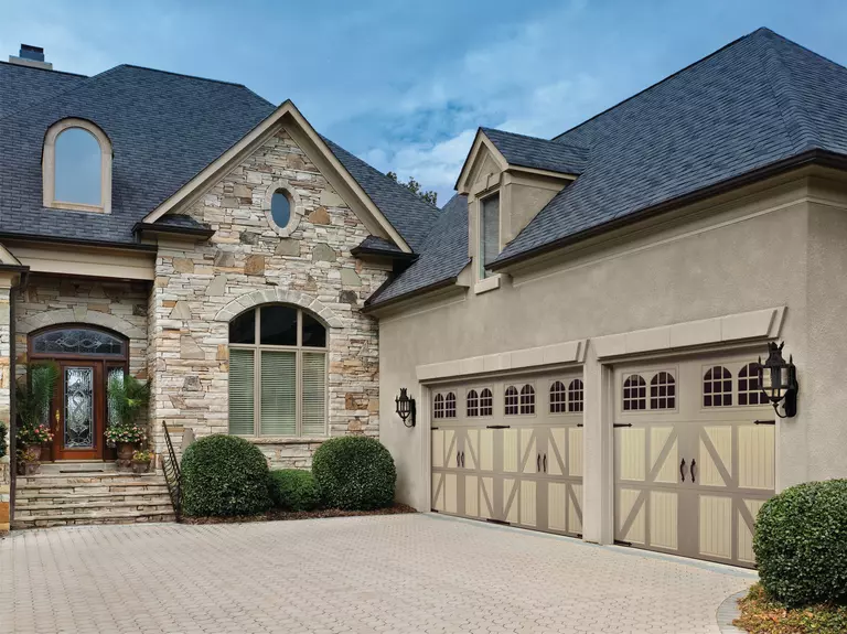 Home with a two-car and single-car carriage house garage door. 