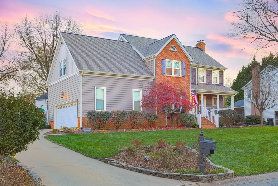 A home with gray shingles and a nicely landscaped yard