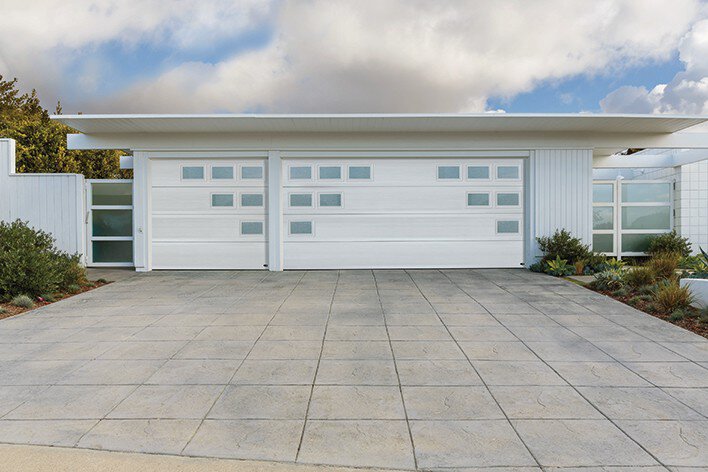 A mid-century modern home with a garage door that includes a geometric design for modern curb appeal