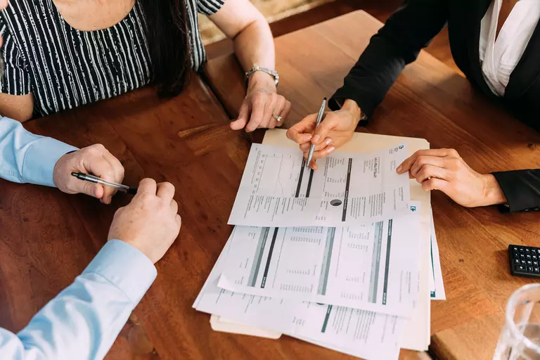 Group of people reviewing financial documents around a table.