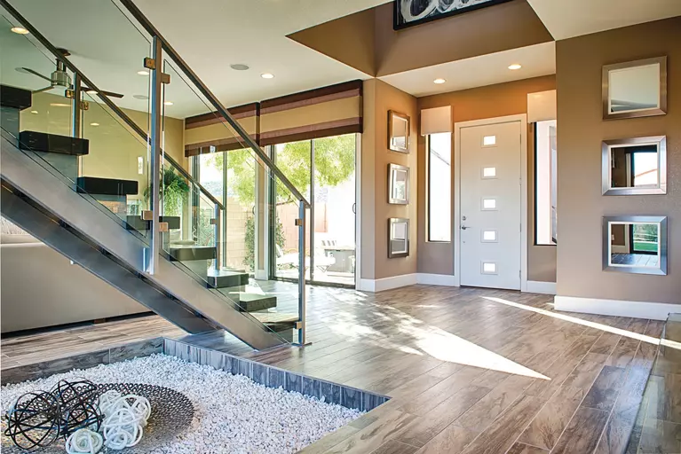 A home’s interior with a contemporary front door with five small rectangular lites.