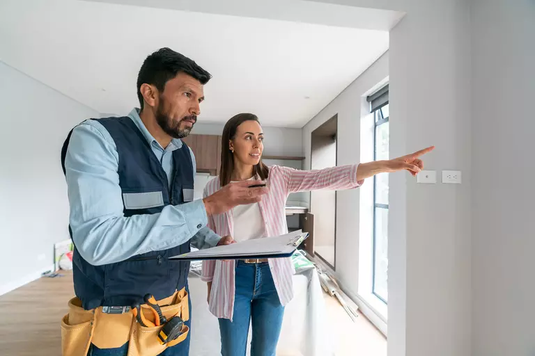 A woman showing a contractor where to begin an exterior remodeling project.
