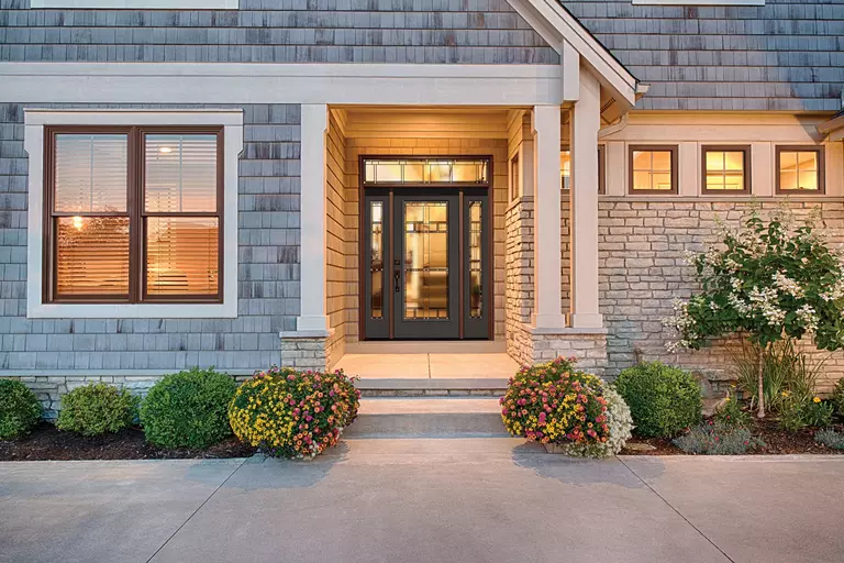 A home with square windows and a front door with glass sidelites and transom.