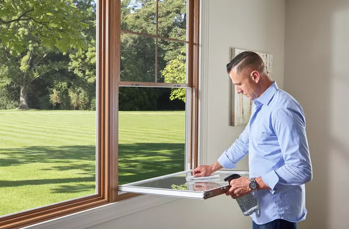 Man cleaning a double-hung window