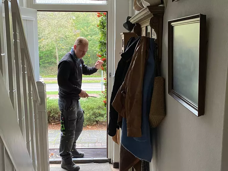 A man installing a new front door.