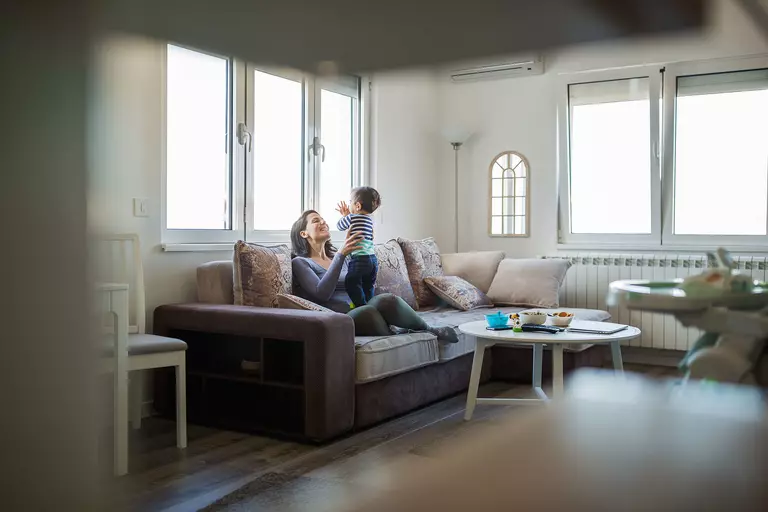 A mother and child enjoying newly installed replacement windows in the living room of their Tri-Cities home.