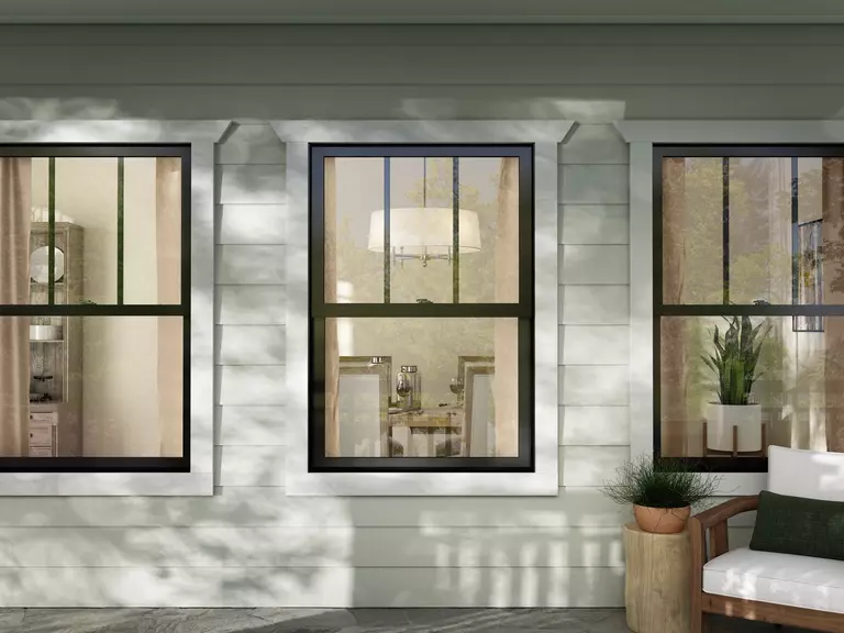 Close-up of front porch of a home with black double hung windows.