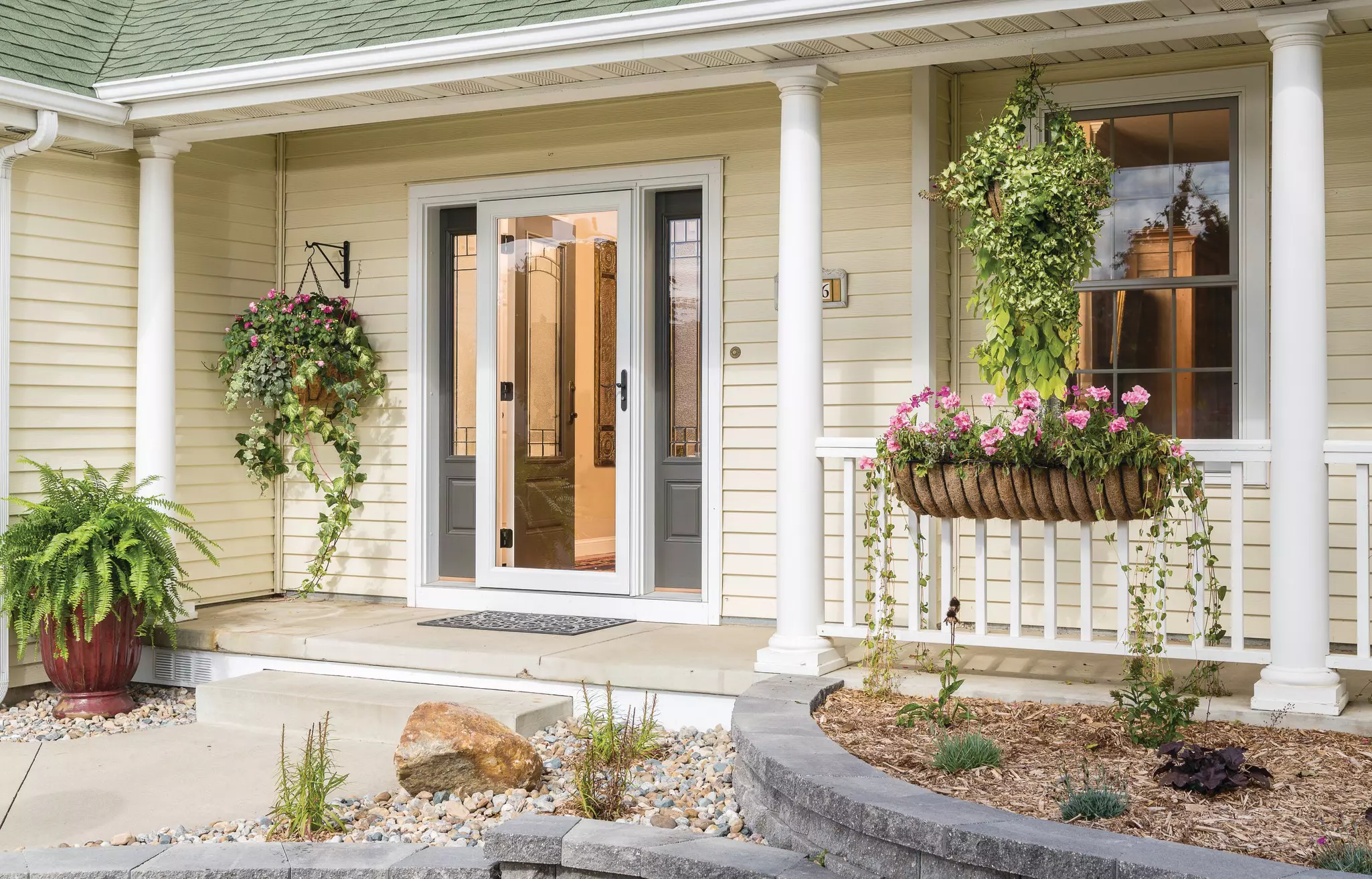 Front porch with entry door, windows, and vinyl siding.