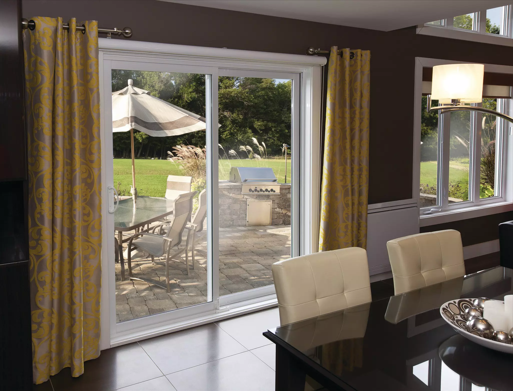 Interior of a dining room with a patio in view outside of sliding glass doors.