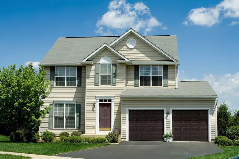 Home with two dark brown raised panel garage doors.