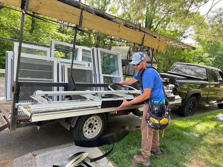 Window World installer unloading equipment from the flatbed of a pickup truck.