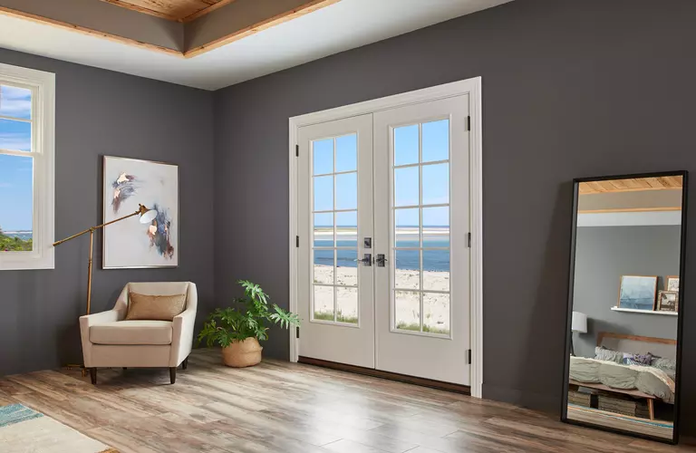 Bedroom with coastal doors that exit to the beach.