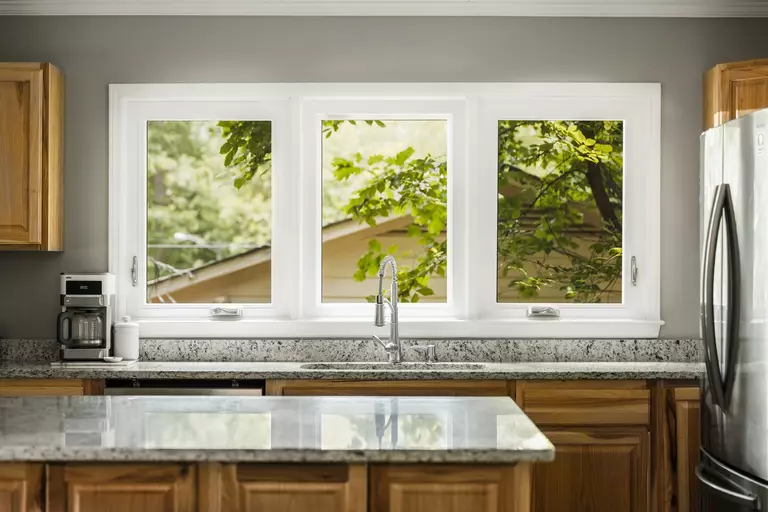 Home kitchen with three similar white windows.