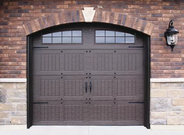 Brown vertical short panel garage door with arched stockton windows and decorative hardware