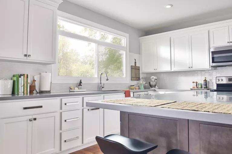 A kitchen with white cabinetry and a matching sliding window over the sink.