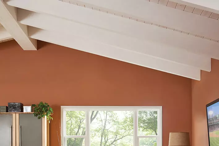 A vaulted ceiling with exposed beams in the living room is included in this ranch home remodel
