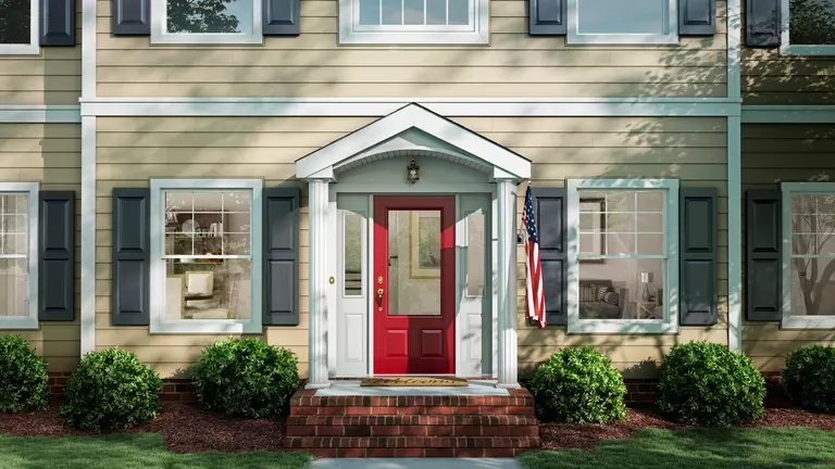 Front of home with beige siding and gray shutters.