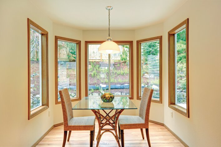 Well-lit dining room of a home surrounded by large window replacements