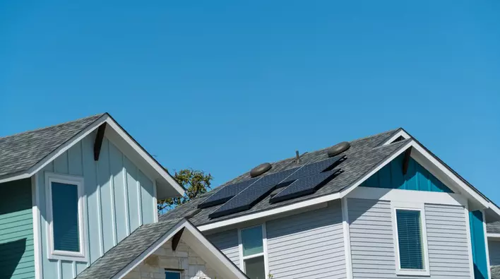 The exterior roof of a home where a portion of the roofing is covered in solar panels to increase energy efficiency throughout the house.