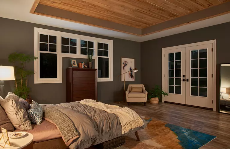 Interior of a bedroom with white windows and doors.