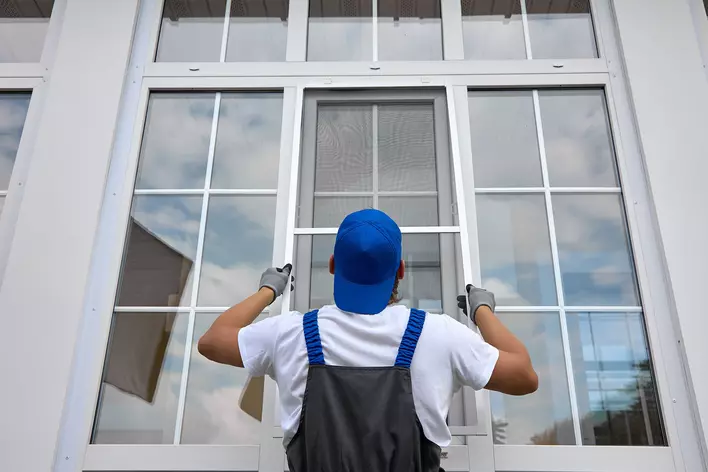 A contractor installing new windows into a home to fix old windows with cracks in pane
seals
