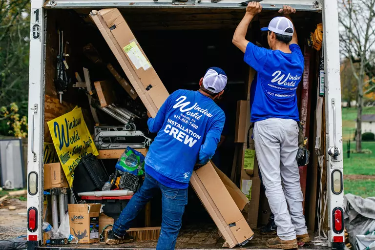 Window World crew hauling garage door materials to be installed.