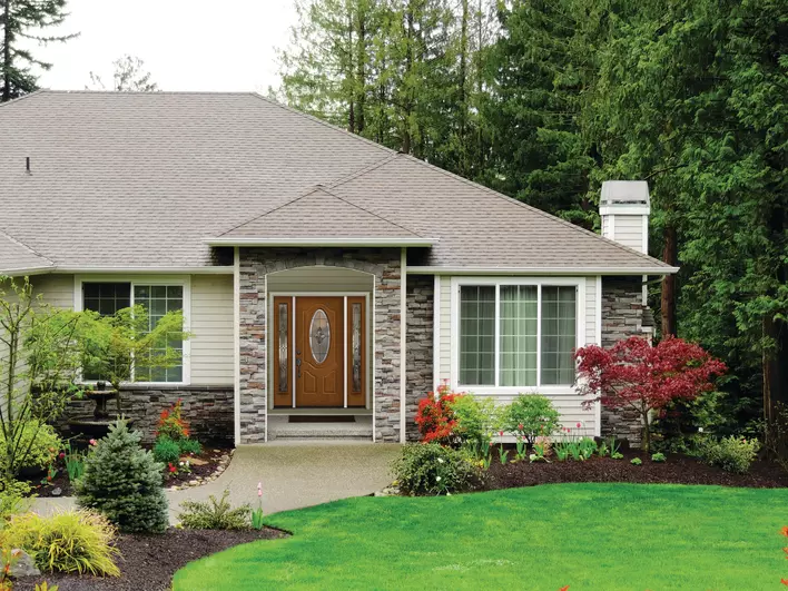 The front view of a well-maintained home, including its energy-efficient front door