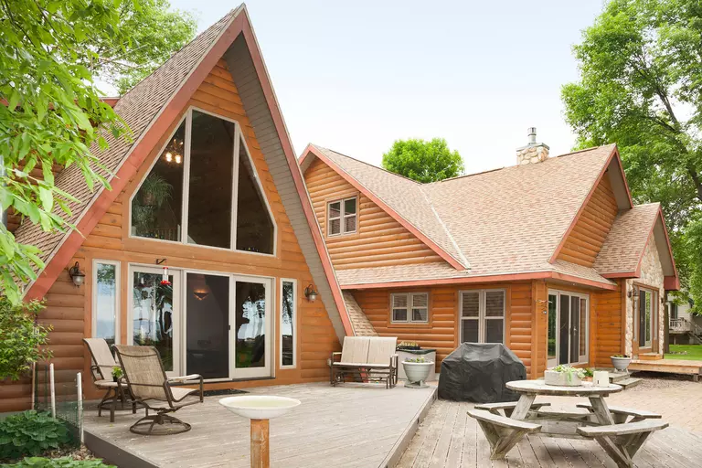  A-frame home with wood siding and large architectural windows.
