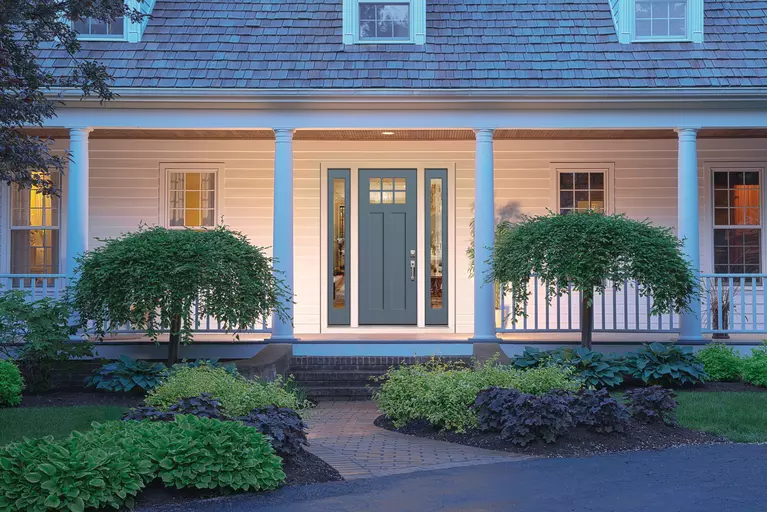 Porch of a home at dusk featuring a fiberglass door with sidelites.