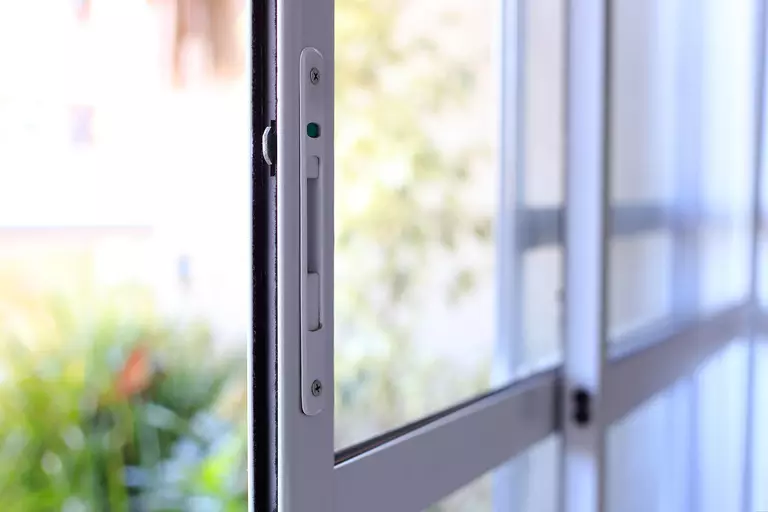 A closeup of the handle of a sliding patio door.