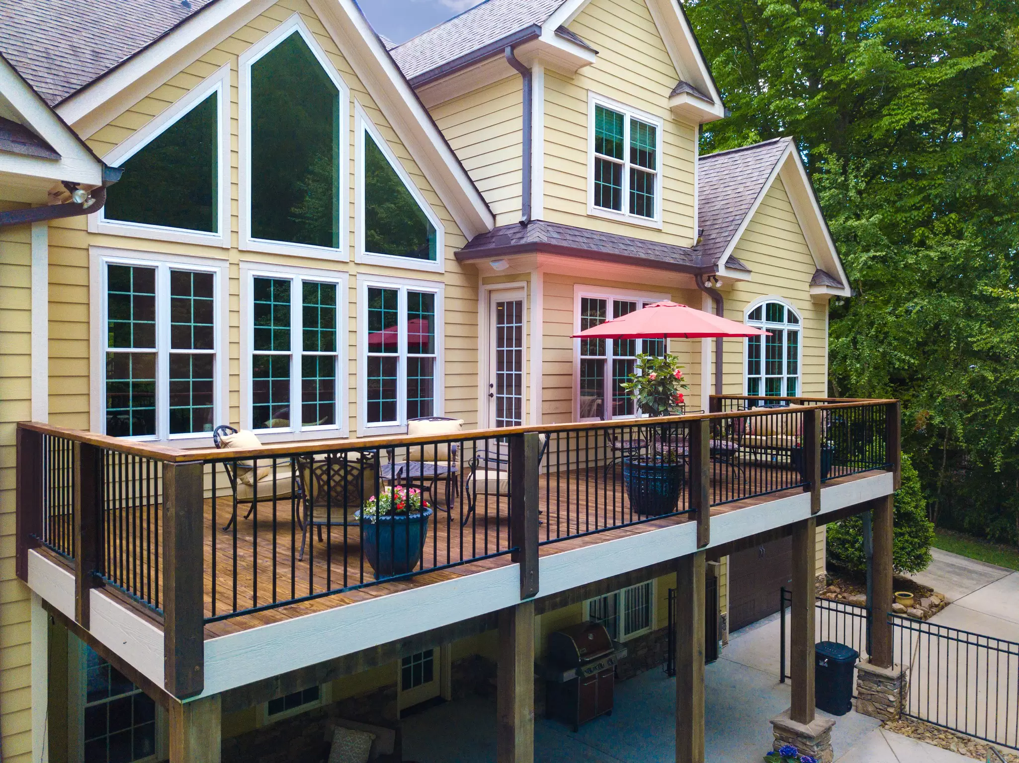 Home with yellow siding, white windows, and an elevated deck.