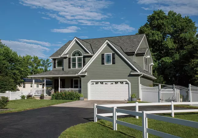 ASCEND Composite Cladding in Mountain Fern, 4" corner post, AMI 4000 Series Charter Oak Soffit and Performance G8 trim coil on a traditional home