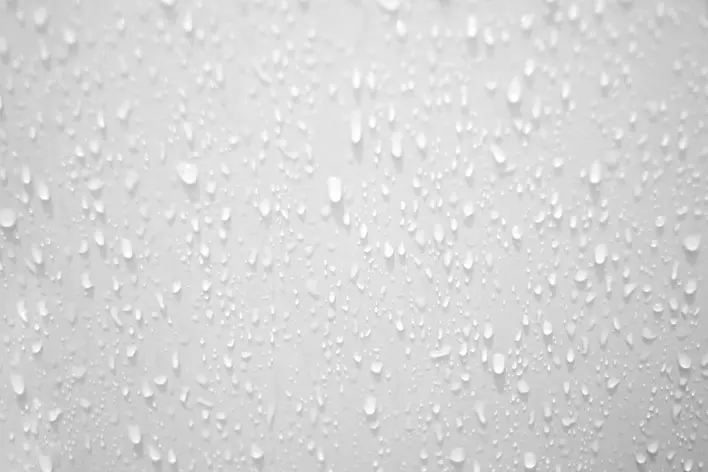 Water droplets collect on a wall in a humid environment