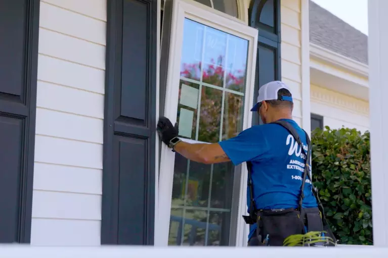 Window World worker installing a window with gridlines for a home.